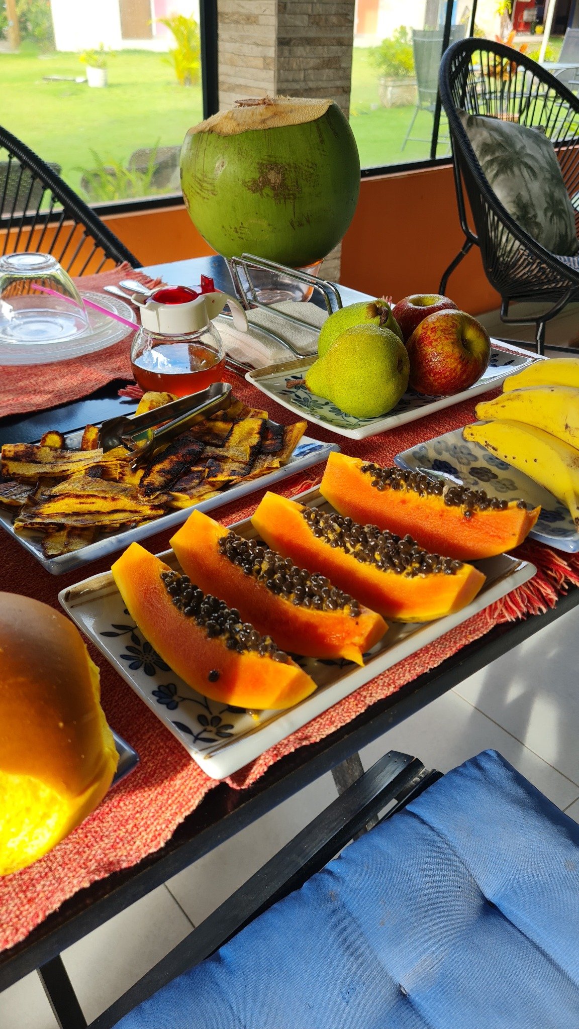 Frutas frescas, mamão, bananas e água de coco no café da manhã